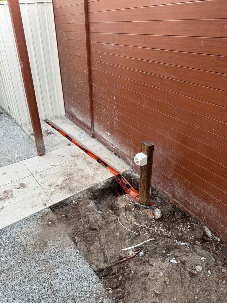Timber post, junction and orange underground feed beside timber cladding at Mossman Court